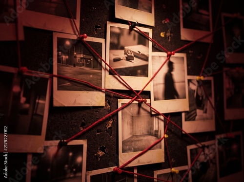 Investigation wall with connected photos and red string for detective work