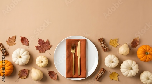 Top view of a festive autumn table setting with white pumpkins and colorful fall leaves