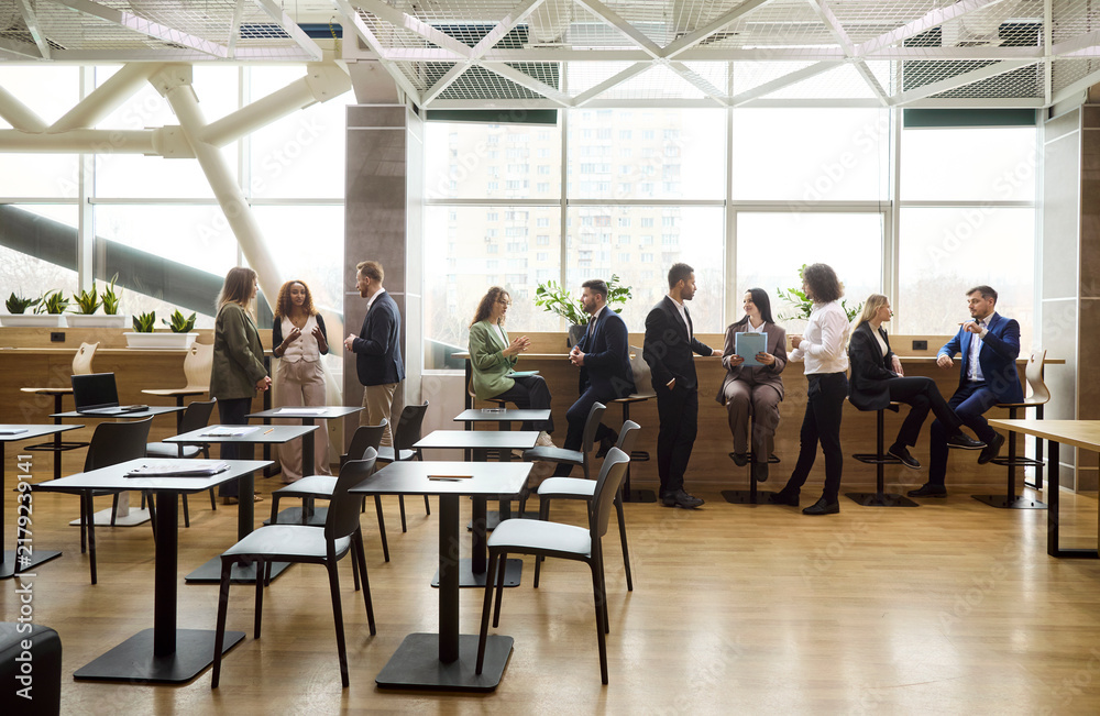 Obraz premium Business team colleagues people in meeting networking. Professionals by windows in an open office exchange ideas plan projects and maintain communication. Teamwork and collaboration idea now.