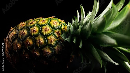 Closeup focused pineapple surface texture isolated on black background strong studio lighting sharp geometric detail and clean framing