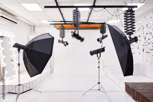 Professional Photo Studio Interior with Lighting Equipment and White Backdrop