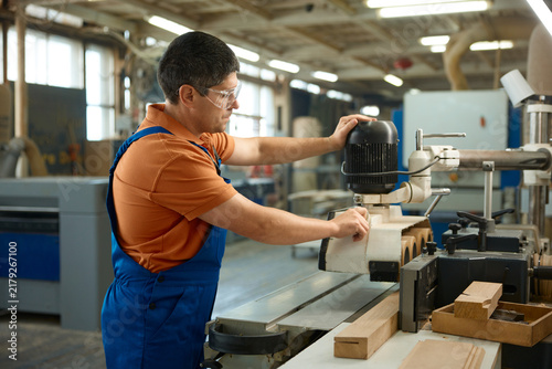 Canvas Print Carpenter adjusting machine settings to ensure consistent thickness and quality
