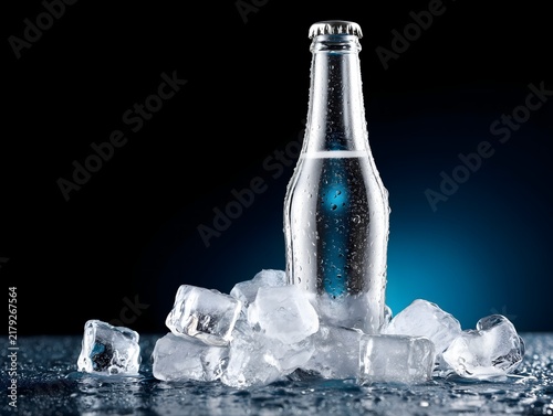Chilled water bottle surrounded by ice with refreshing blue tones and condensation