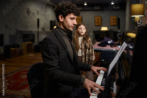 Studio with girl and teacher practicing instruments