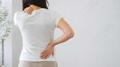 Naklejka 首こりと腰痛に悩み背中を押さえる女性の後ろ姿