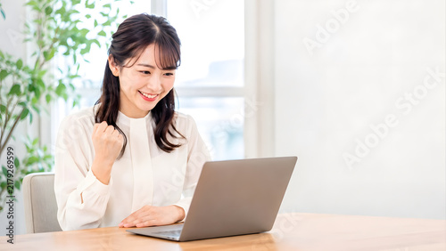 Obraz w ramie ノートパソコンを見ながら成功を喜ぶ日本人ビジネス女性