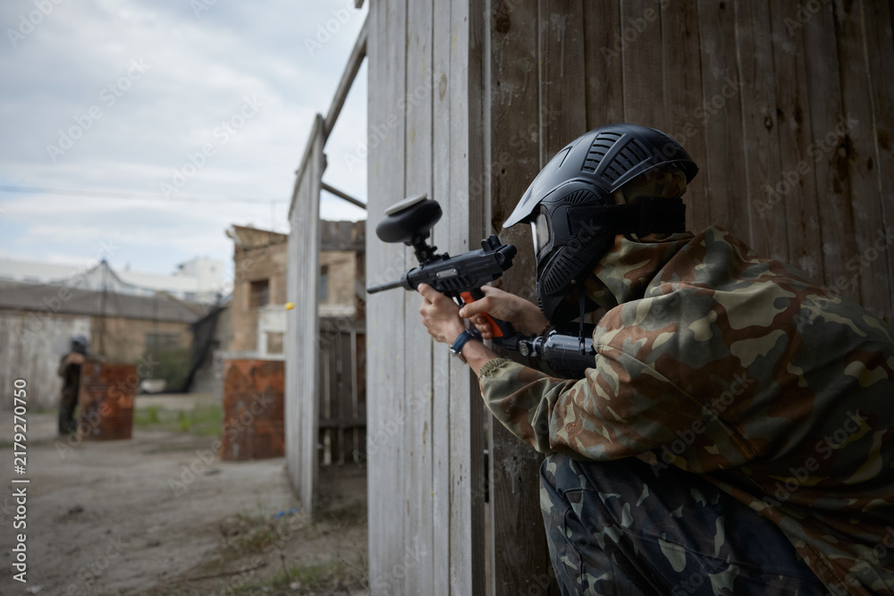 Obraz premium A soldier is taking a defensive position behind the cover during tactical weapon training