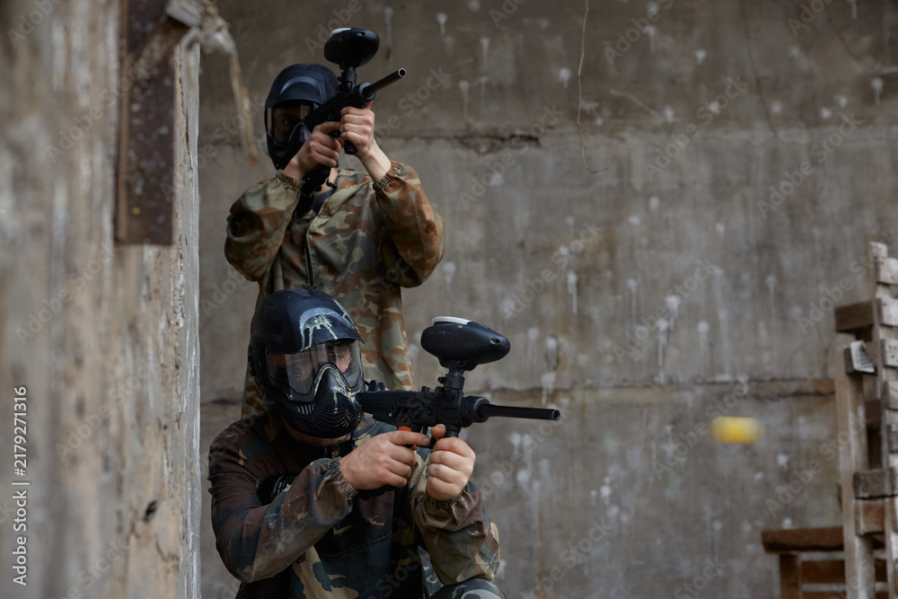 Obraz premium Two soldiers aim their weapons while taking up comfortable positions on a training field