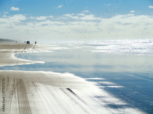 Fotografie Glowing mirror-like beach with blue sky