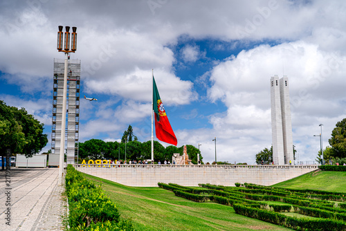 Принти на полотні Eduardo VII Park in Lisbon with monuments, plane flying over Lisbon and people, flagpole in Portugal