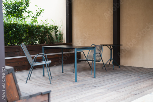 Obraz na płótnie A covered outdoor seating area features table and several chairs arranged on wooden flooring