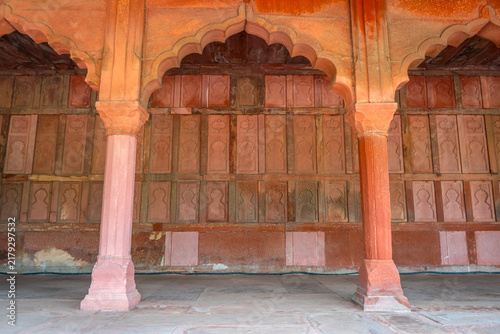 Intricate red sandstone scalloped arches and carved pillars inside historic gallery hall at the Taj Mahal complex in Agra, Uttar Pradesh, India.