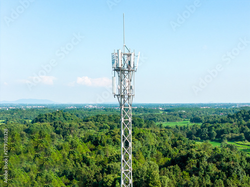 Communication signal tower rising from lush green forest