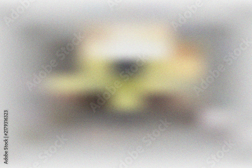Artistic abstract composition with soft blurred shapes of yellow and beige on a subtle grainy gray textured surface