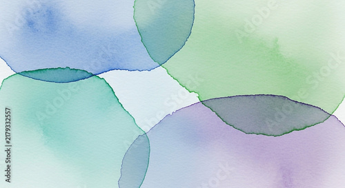Soft, translucent watercolor circles in blues, greens, and purples overlap gently