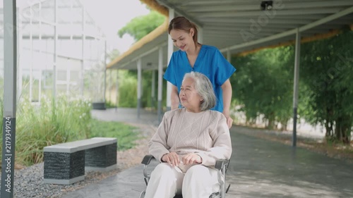 Caregiver help and care Asian senior or elderly old lady woman patient sitting in wheelchair on ramp at nursing hospital, healthy strong medical concept