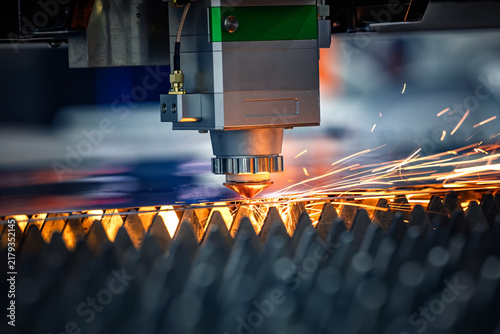 Industrial CNC laser cutting machine with flying sparks in metal fabrication.