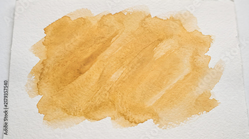 Golden Amber Watercolor Brush Stroke Texture on Textured Paper Background