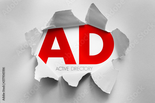 AD Active Directory text shown through torn paper background, enterprise technology concept representing centralized user authentication, access management and network administration
