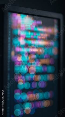 Abstract blurred programming code on a dark developer screen