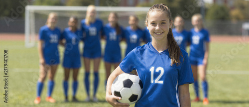 Confident teen soccer player with team