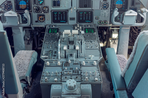 Canvastavla Wide view of an analogue and early glass cockpit with instrument panels, control columns and throttle quadrant inside a parked passenger jet