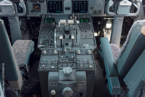 Canvastavla Interior of a classic airliner flight deck with throttle quadrant, radio panels with green displays and two pilot seats with sheepskin covers