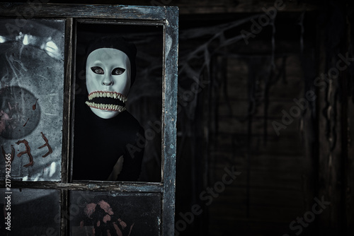 Bild auf Leinwand Masked creature peeking through old window