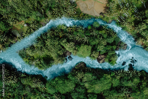 Fotografie Aerial Top View of a Turquoise Tropical River Flowing Around a Lush Jungle Islan