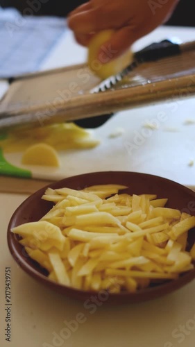 Slicing raw potatoes with mandoline slicer in kitchen video