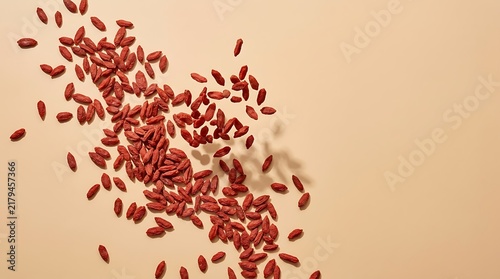 Goji berries top view on a light background, overhead flat lay composition showcasing dried red superfood fruits