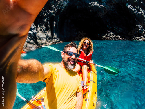 Konstfotografi Happy couple enjoying a summer adventure, taking a selfie while kayaking on clea
