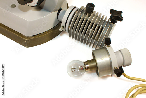 Foto Vintage microscope illuminator with incandescent bulb, metal heat sink and adjustable light housing, photographed as scientific laboratory equipment on a white background