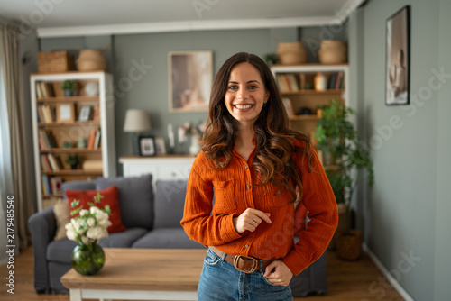 Foto Smiling woman standing in modern cozy living room