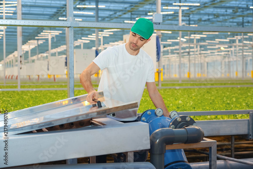 Konstfotografi Man inspects the water pump machinery and maintenance panel within a commercial