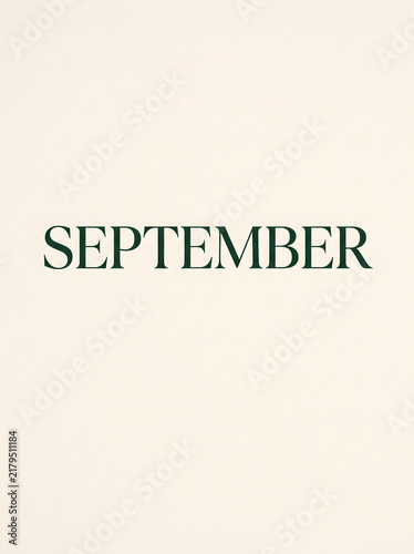 Minimalist typography poster with the word September written in elegant green serif capital letters on a soft neutral cream background