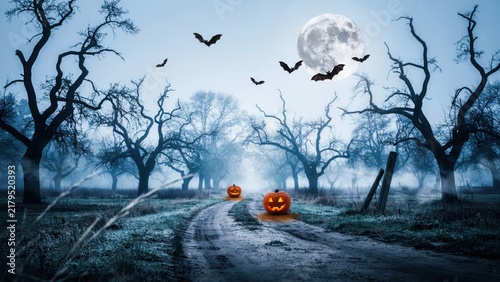 Spooky halloween dirt road path under bright full moon with flying bats and glowing jack o lanterns.