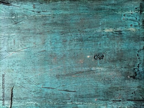 Old rustic wood grain background featuring peeling light blue paint and a rugged, time-worn texture.
