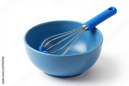 Blue ceramic mixing bowl with matching wire whisk for baking preparation.