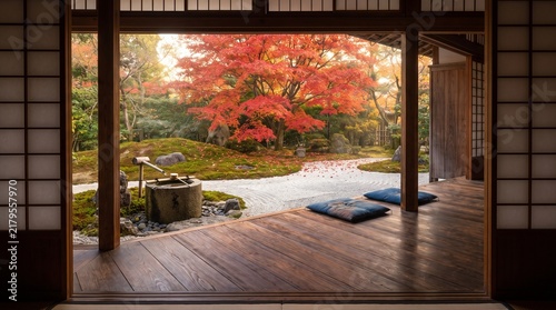 Traditional Japanese room opening to a peaceful autumn zen garden. Features a wooden veranda, floor cushions, raked sand, stone basin, and vibrant red maple trees. Serene fall nature background