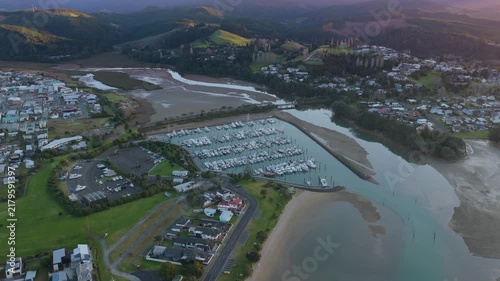 Aerial view of moored boats in the Whangamata Marina at sunrise, highlighting the coastal town in Whangamata, New Zealand.