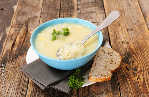homemade onion soup with bread on rustic wooden table