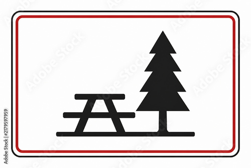 A road sign depicting a picnic table and a tree, indicating a rest area or park.