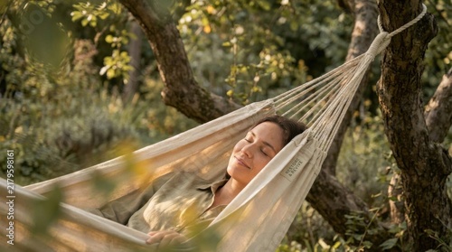 Woman Relaxing in Hanging Hammock Among Green Trees in Nature