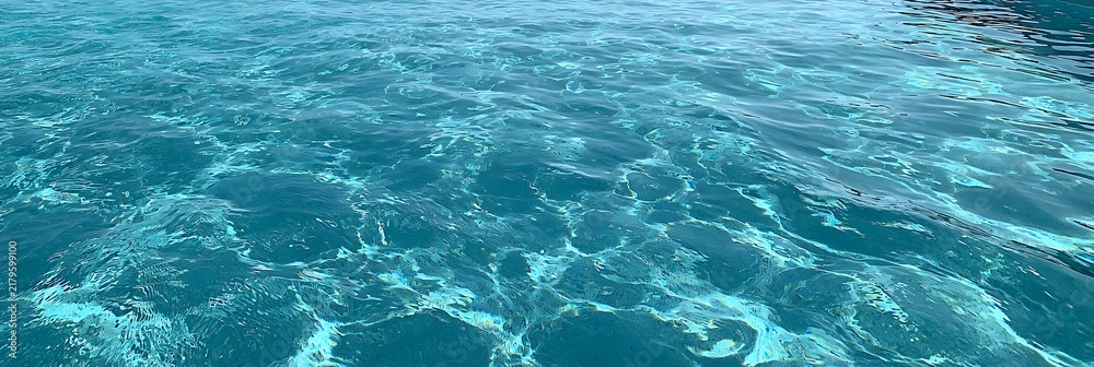 Fototapeta premium Water ripple seamless background texture - top view of clean, clear, blue water ripples. Image can be tiled to create a larger image or higher resolution background. Water has the chemical formula H2O