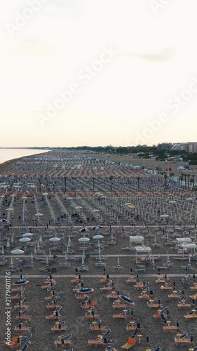 Empty italian beach with closed umbrellas at sunrise