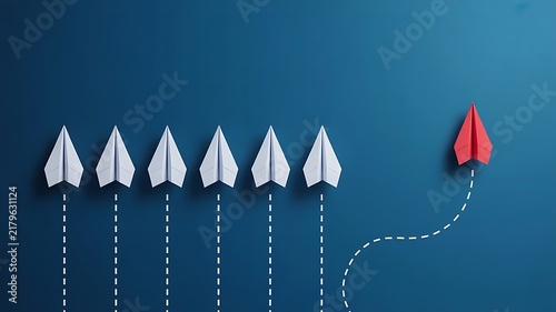 Red paper airplane flying away from a group of white paper airplanes on a dark blue background, representing leadership and, strategic innovation