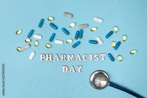 Foto Pharmacist Day concept with stethoscope and colorful pills surrounding celebrato