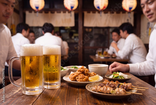 Naklejka 賑わう日本の居酒屋で楽しむ生ビールと料理・仕事帰りの飲み会
