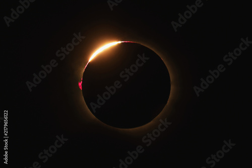 View of a total solar eclipse showing the diamond ring effect with a bright flare of sunlight emerging from behind the moon in Bellmunt del Priorat, Catalonia, Spain.